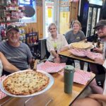 Group of friends enjoying pizza inside a casual restaurant
