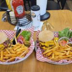Two cheeseburger baskets with fries on a restaurant table