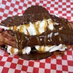 Chocolate-topped dessert with bacon and whipped cream
