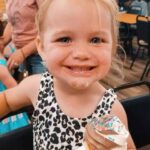 Smiling toddler holding a soft-serve ice cream cone