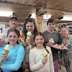 Family group holding ice cream cones inside a restaurant