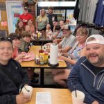 Group of diners smiling at tables inside the restaurant