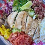 Grilled chicken salad with tomatoes, lettuce, cheese, and vegetables