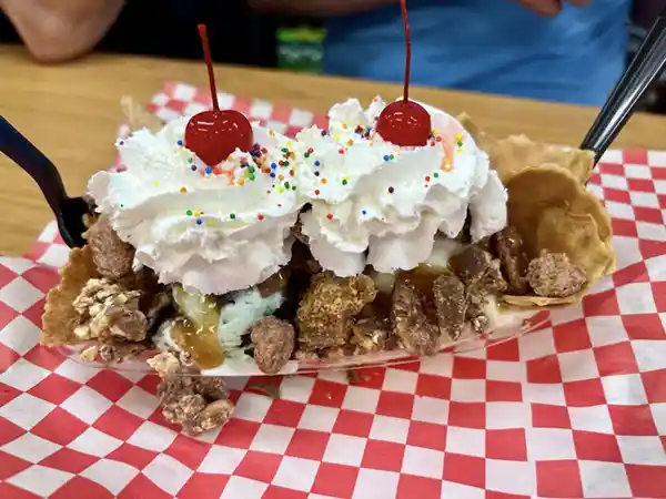 Ice cream sundae topped with whipped cream and cherries